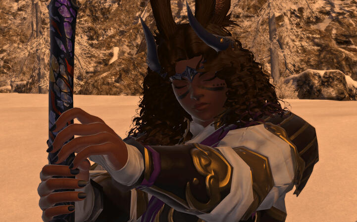 Emery is holding out an odachi, pointed into the ground. She is wearing black armor with gold trim, a matching headpiece shaped like a pair of horns, and a white tunic underneath that covers the base of their hands. She appears lost in thought.